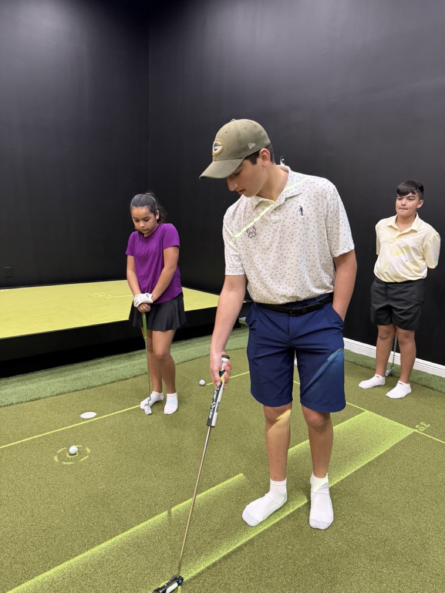 Junior golfers practicing on the putting green at the Trump Golf Academy